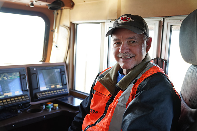 Brett in the engineer’s seat of a locomotive.